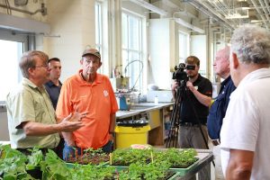 Pat Wechter shows watermelon seedlings to Dr. Perdu