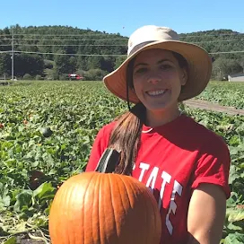 kim heagy holding a pumpkin in the field
